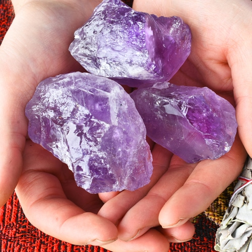 hand-holding-three-purple-amethyst-crystals