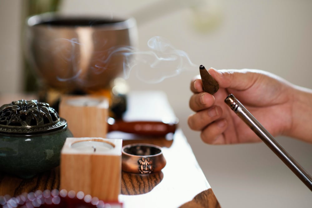 side view of man lighting incense